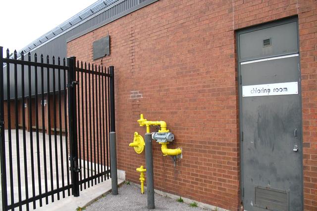Black steel fence and gate beside a brick building