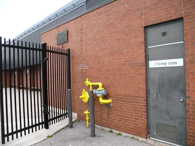 Black metal gate beside a brick wall