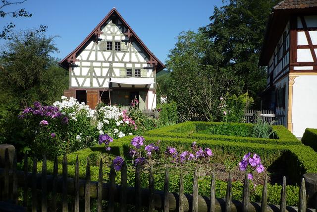 Garden with flowers and a low fence in front of a house
