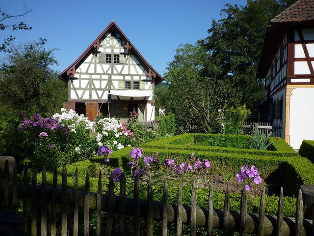 Garden with flowers and a low fence in front of a house