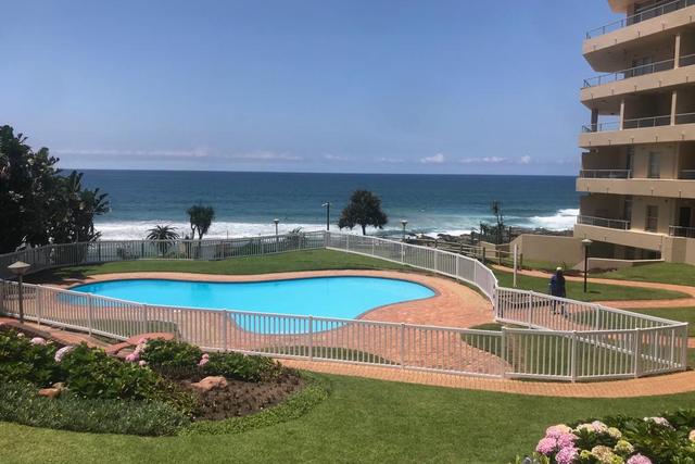 Swimming pool with a low fence and garden beside the sea