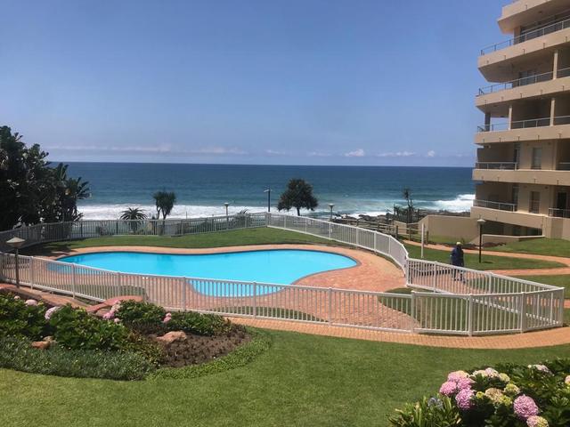 Swimming pool with a low fence and garden beside the sea